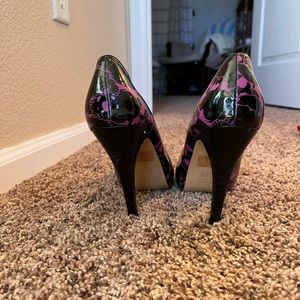 Black and purple pumps with skull designs and bow detail.